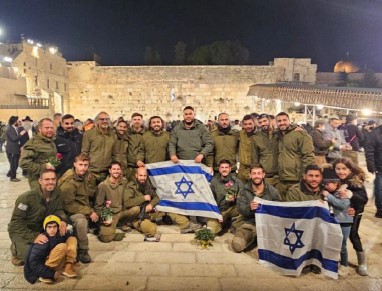 חיילים מצטלמים עם שני דגלי ישראל שברקע הכותל